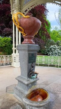 The Snake Spring, Hadi pramen. Karlovy Vary has famous mineral water sources that flow from fountains. Visitors fill their cups and taste the waters while enjoying the surrounding area in the town.