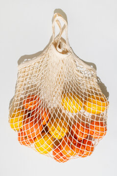 Fresh lemons and mandarins inside mesh bag present vitamin rich nutrition concept, citrus inspired healthy eating, natural produce selection, vitamin focused branding, educational wellness content.