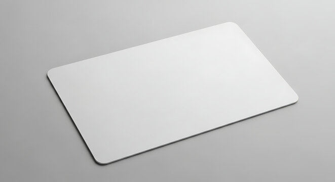 Blank white rectangular mouse pad rests on a light gray surface a studio product shot