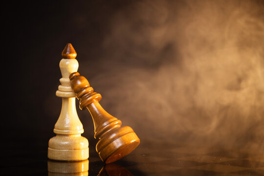 king and queen piece on a chessboard on a dark background
