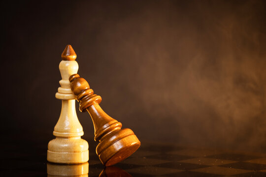 king and queen piece on a chessboard on a dark background