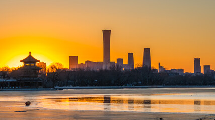 Obraz premium The winter sunset over the frozen lake at Shichahai in Beijing, China, offers a blend of ancient and modern scenery.