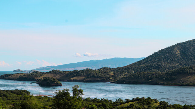 Scenic coastal view with rolling hills and waters under a clear sky
