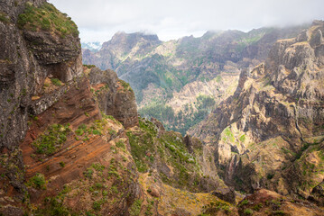 Fototapeta premium Panoramic view of deep valleys and volcanic ridges from the Pico do Areeiro trail, Madeira