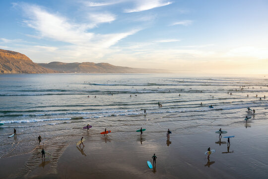 Surfers enjoying Imsouane long wave at sunset in Morocco