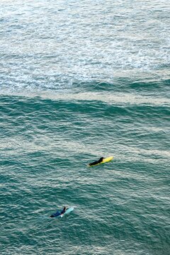 Surfers on longboards waiting for waves in ocean at Imsouane, Morocco