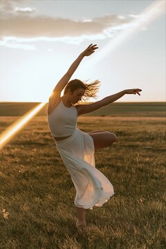 Graceful female dancer performs in a golden field