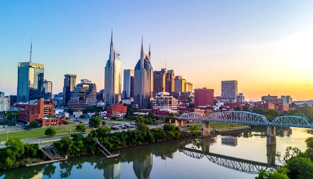 Aerial view of a city skyline at sunset, with tall buildings silhouetted against a golden sky and a river below