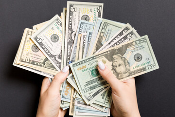 Top view of different dollar banknotes in female hands on colorful background. Business and...