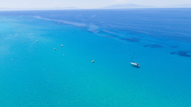 Turquoise sea with sailboat and small boats