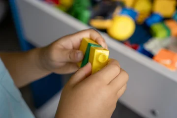 Fototapete Lego Child's hands playing with colorful building blocks  © Zhaorui