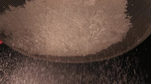 Fine Flour Falling Through Metal Sieve in Slow Motion for Baking Preparation