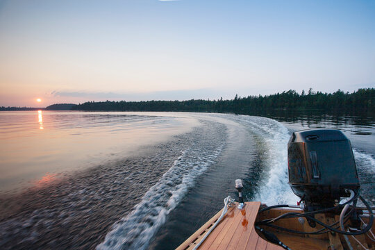 Motorboat wake on Saranac Lake at sunset