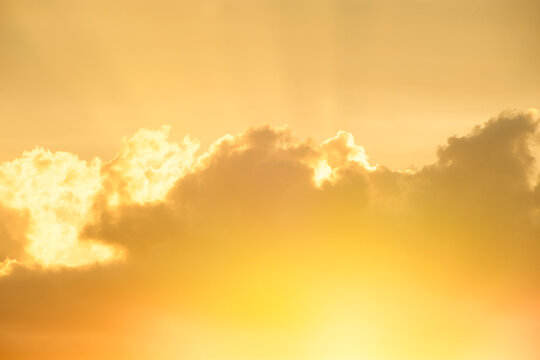 Setting sun shining through gold clouds