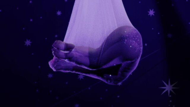 Acrobat girl performs aerial dance in purple net with sparkling costume under starry sky, graceful movement of performer at circus show slow mo