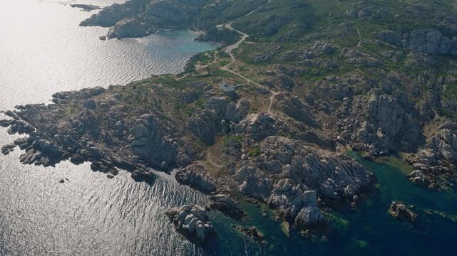 Drone footage above the wild Capo Testa peninsula in Sardinia, showcasing sculpted granite rocks, winding trails, hidden coves and clear blue Mediterranean water.