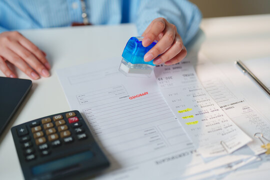 Close-up of an approved expense report with stamped invoice, receipts, and calculator, expense approval, reimbursement, financial control, bookkeeping, auditing, and business administration