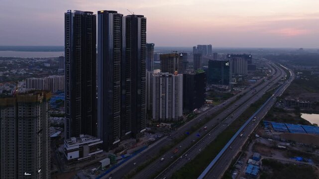 skyscrapers with 8 lane outer ring road, service road, traffic flow, solar cycle track and sky at kokapet, hyderabad, telangana, india. day time, static shot, drone shot, 4k.