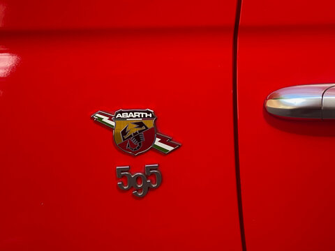 Abarth 595 badge and emblem on a vibrant red car door