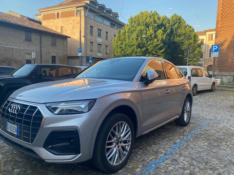 Silver Audi Q5 parked on cobblestone street in European town