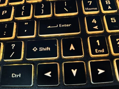 Close-up of computer keyboard numeric section with warm orange backlighting keyboard computer