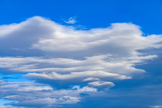 White lenticular clouds on blue sky