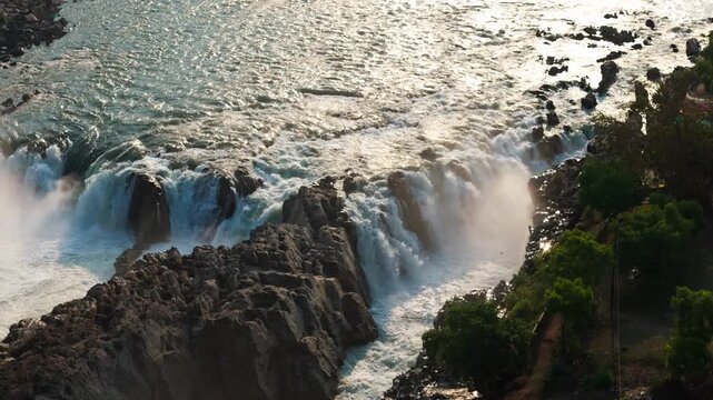 Smooth left-panning 4K drone footage of Dhuandhar Waterfall on the Narmada River at Bhedaghat, Jabalpur, Madhya Pradesh, India, captured during an early spring morning in natural light.