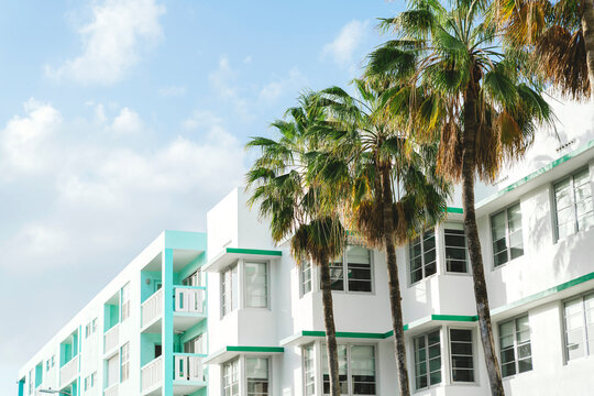 Art deco buildings and palm trees against sky during sunny day, Florida, USA