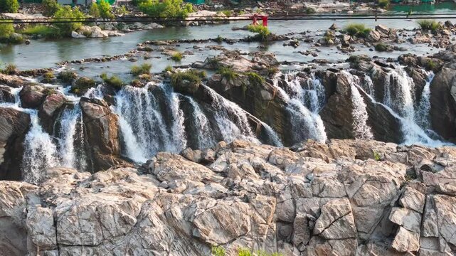 Slow cinematic 4K drone footage during the early morning in late March, featuring a smooth left panning aerial view of Dhuandhar Waterfall on the Narmada River at Bhedaghat, Jabalpur, Madhya Pradesh