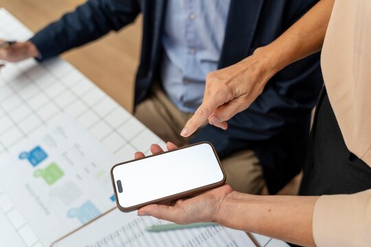 Person showing blank smartphone screen in office meeting