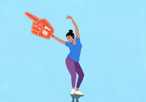 Carefree, happy woman with #1 foam hand cheering with arms raised, celebrating
