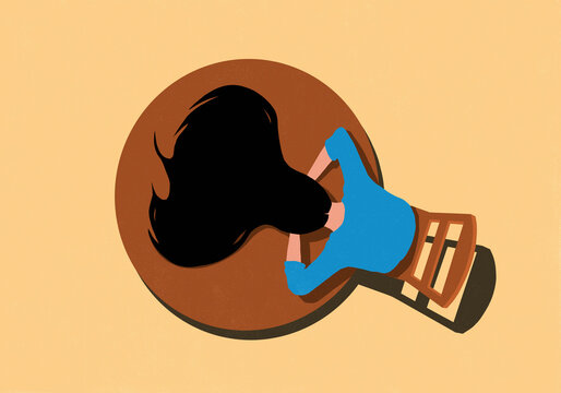 View from above of woman with long hair laying face down with head on round table and hair flowing