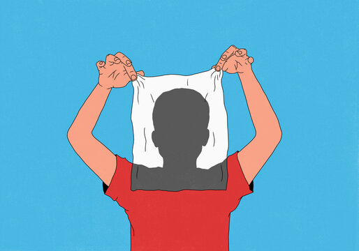 Man holding semitransparent towel over face, revealing silhouetted head against blue background