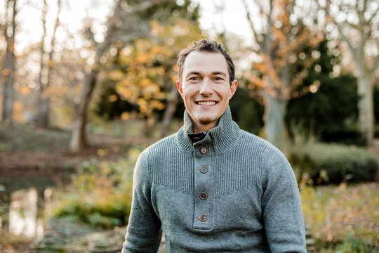 Smiling handsome man sitting in public park