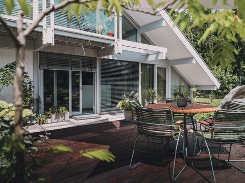 Modern timber frame villa with outdoor dining area on wooden deck