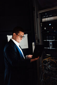 Male administrator checks the network on a laptop in the office