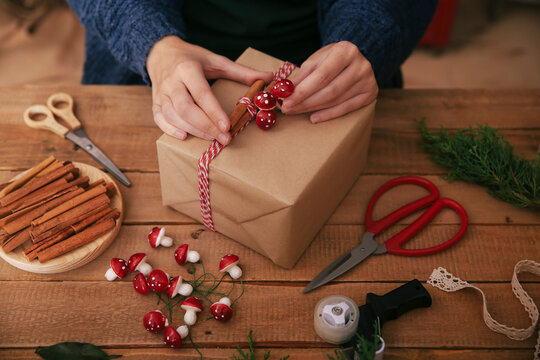 Woman's hands decorating Christmas present