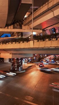 Asia, China, Shanghai, day to night cityscape vertical time lapse of road intersection in central Shanghai, busy with rush hour traffic and commuters