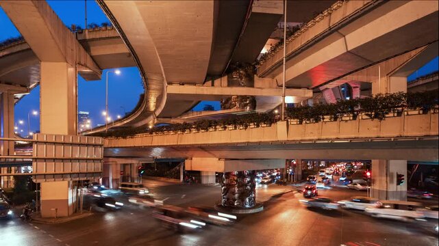 Asia, China, Shanghai, day to night cityscape time lapse of road intersection in central Shanghai, busy with rush hour traffic and commuters