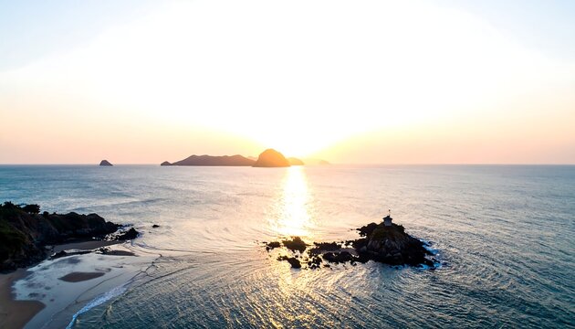 Aerial view of a coastline at sunset, featuring a small island with a structure and golden light reflecting
