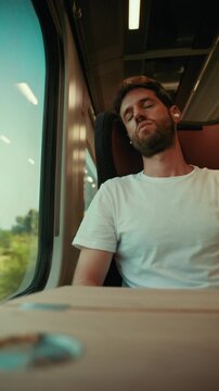 Italian Man sleeps seated on the train while listening to music earphones