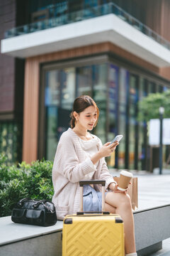 Young adult asian business woman using smartphone texting message work and travel on the go urban lifestyle