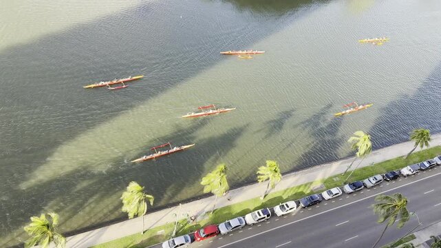 Outrigger boat or Canoe is a watercraft. Ala Wai Canal is an artificial waterway in Honolulu, Oahu, Hawaii. northern boundary of the tourist district of Waikiki. Coconut palm tree (Cocos nucifera)