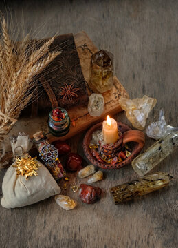 witchcraft items - candle, spell books, amulets, wheat ears and gemstone crystals on table close up. Witchcraft. crystal ritual. Esoteric spiritual ceremony. practical magic. top view