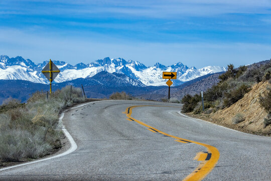 Empty two-lane highway through desert to mountains