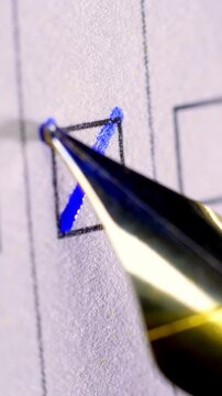 Marking a Checkbox with Blue Ink. Macro view of a fountain pen drawing a blue X inside a printed checkbox. Suitable for surveys, voting, and decision concepts.