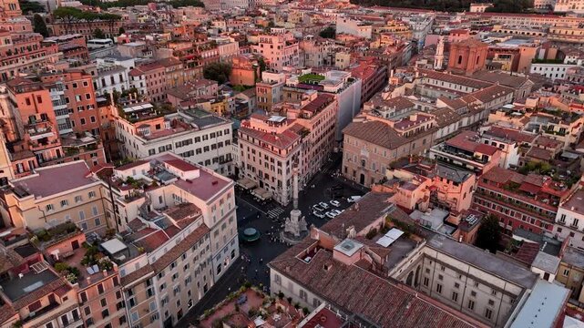 Dense historic blocks, rooftop terraces and a narrow street intersection sit in warm evening color as the camera slowly ascends.