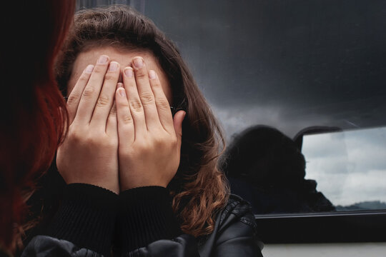 Teenager mental health, stress and anxiety concept, sad teen covering face with hands. Sadness, depression, despair, emotional trauma, peer pressure, school stress. Young adolescent girl hiding face