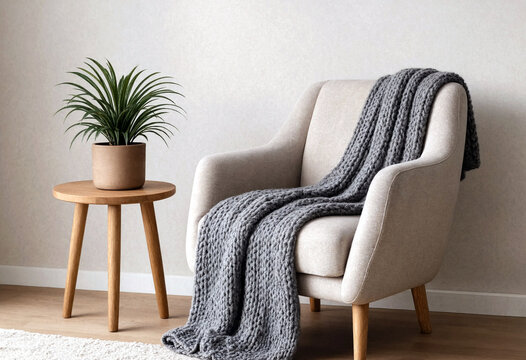 Modern cozy living room with light gray armchair knitted blanket and small indoor plant decor
