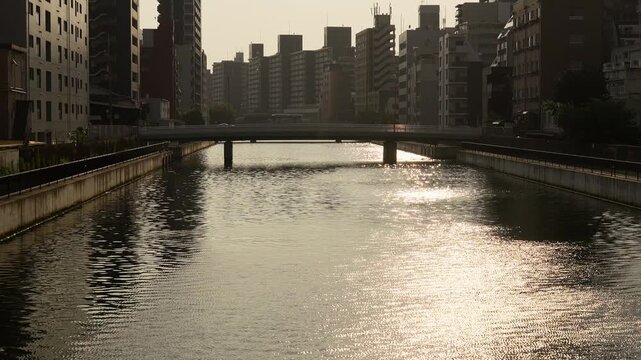 夕暮れ時の太陽に照らされてキラキラ輝く道頓堀川の水面のスローモーション